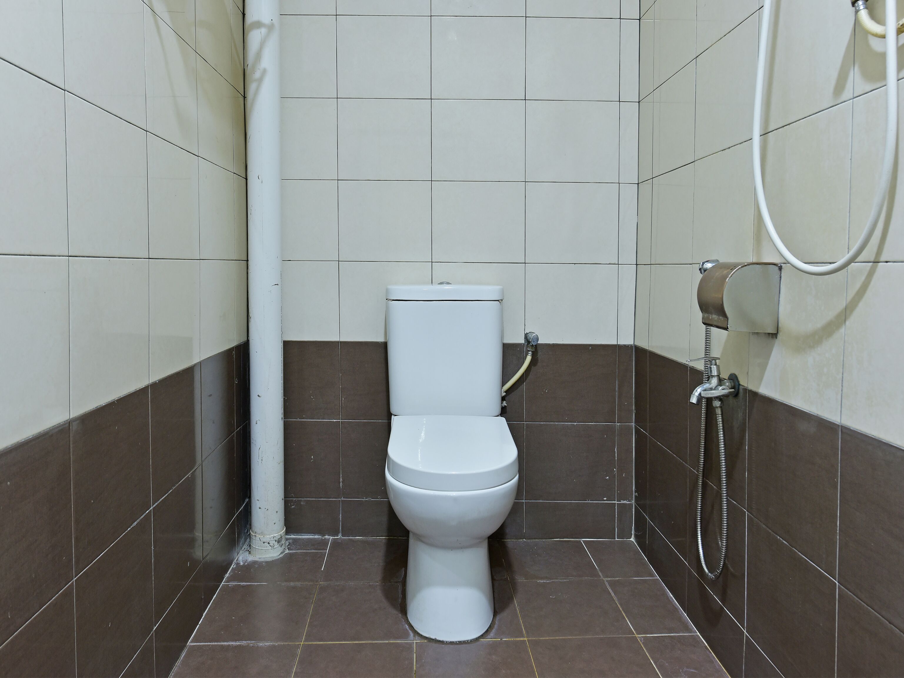 A small, clean bathroom with a toilet, a shower, and a towel rack.