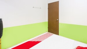 A room with a bed, a door, and a wall-mounted shelf. - Hotel O Bagus Stay (Tanjung Pinang)