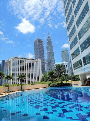 A modern hotel with a swimming pool featuring a geometric tile pattern.