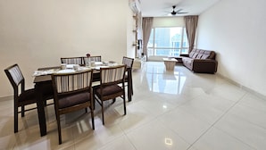 A modern living room with a dining area, a sofa, and a ceiling fan. - Crest Residence Klcc  (Kuala Lumpur)