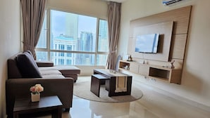 A modern living room with a sofa, coffee table, and TV mounted on the wall. - Crest Residence Klcc  (Kuala Lumpur)