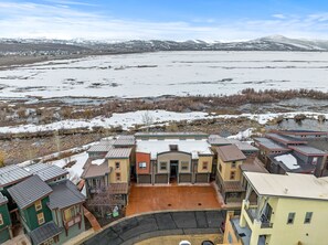 Un quartier résidentiel composé de maisons, avec une cour centrale et une grande étendue d’eau en arrière-plan.
