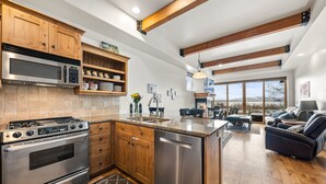 A modern kitchen with wooden cabinets, stainless steel appliances, and a large island. - Newpark, Close to ski resorts and restaurants, Amazing Views, Private hot tub (Park City)