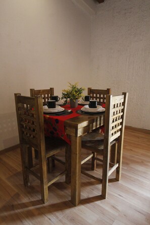 Dining area with a table set for four, featuring a centerpiece and comfortable seating.
