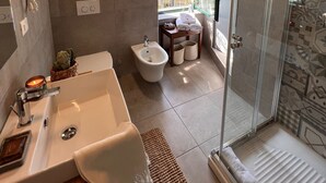 A modern bathroom with a large sink, bidet, and glass shower enclosure. - Apartment "La Brezza" (Cavallasca)
