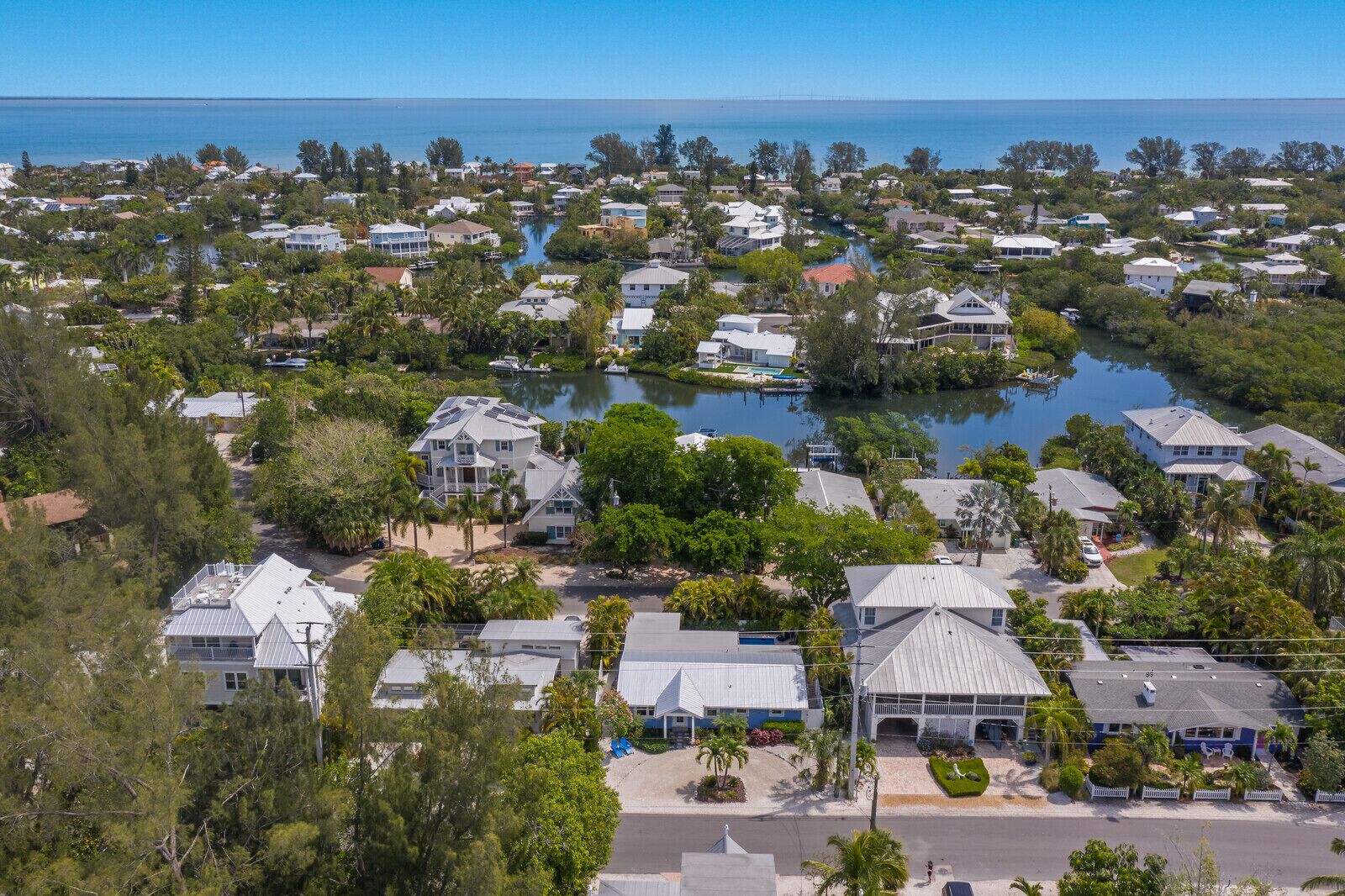 A coastal residential area with houses, a marina, and a large body of water.