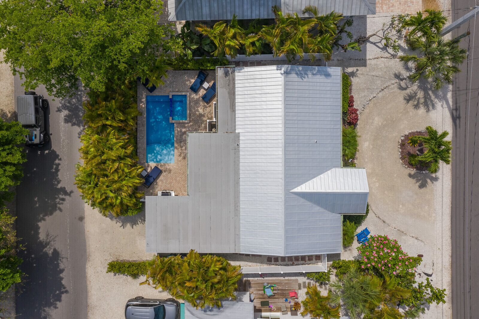 Vue aérienne d’une propriété résidentielle dotée d’une piscine, d’un patio couvert et d’un garage.