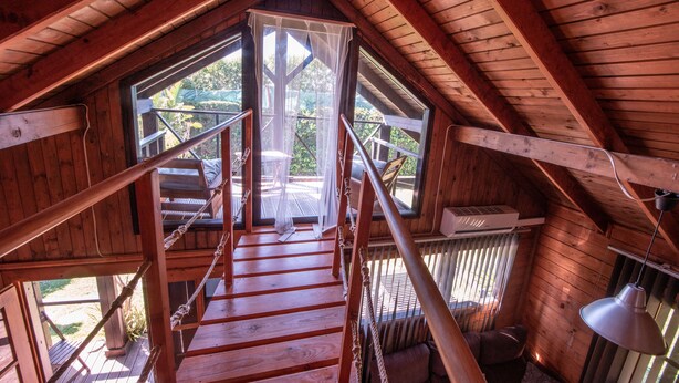 A wooden staircase leading to a balcony with a view of greenery outside. - La Peña Luxury Tarifa (Tarifa)