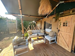 Un espacio de estar al aire libre cubierto con muebles de madera y vistas del paisaje circundante.
