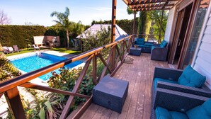 A wooden deck with a pool, outdoor furniture, and a pergola. - La Peña Luxury Tarifa (Tarifa)