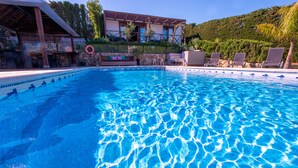 A clear blue pool with lounge chairs and a building in the background. - La Peña Luxury Tarifa (Tarifa)