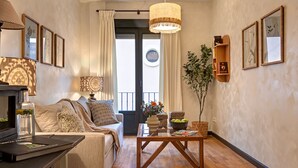A cozy living room with a sofa, a coffee table, a lamp, and framed pictures on the walls.