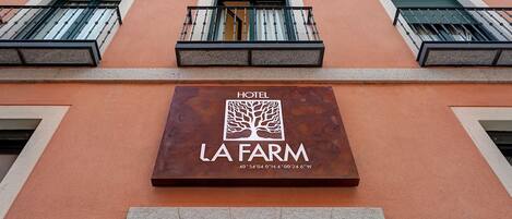 Un letrero de hotel con el nombre "La Farm" y un logo de árbol.
