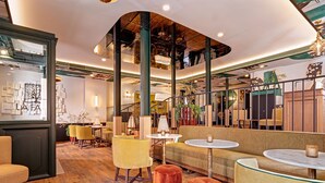 A spacious lounge area with high ceilings, wooden beams, and a variety of seating options including sofas and chairs.
