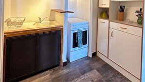 Una cocina compacta con lavamanos, cocina y armarios.
