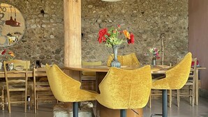Un interior moderno con pared de piedra, muebles de madera y una zona de bar.