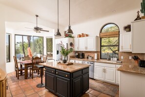 Enjoy cooking in this well-equipped kitchen with a large island, modern appliances, and a dining area with a view.