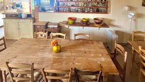 Una cocina rústica con gabinetes de madera, una isla central y lámparas colgantes.
