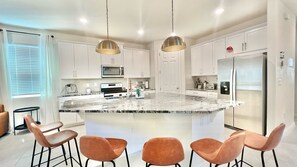 Enjoy cooking in this well-equipped kitchen with a central island, bar stools, and ample storage.