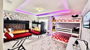 A room with bunk beds, a red sofa, and a small table. - Pool, Spa, Game Room, Theater, 4 Miles to Disney! (Kissimmee)