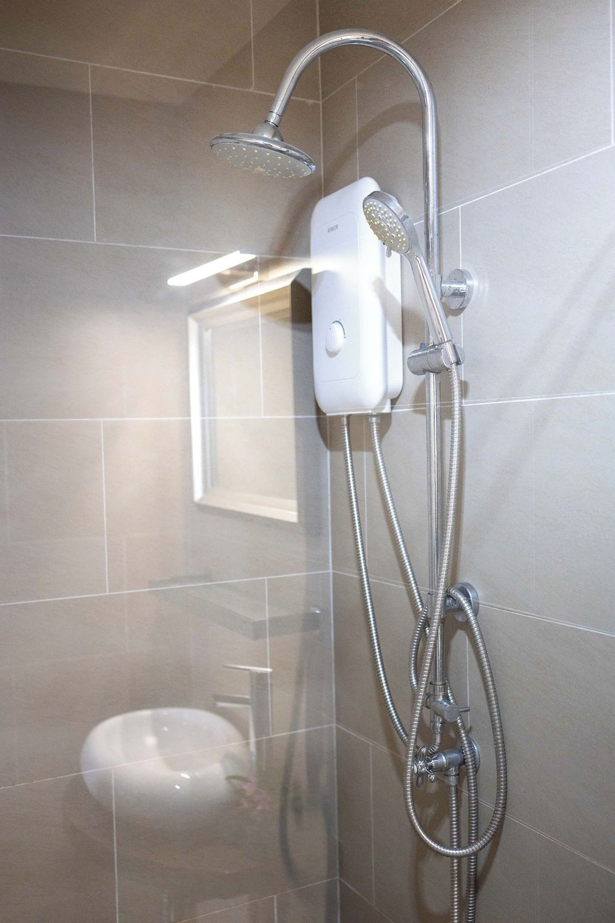 En bruser med håndbruser og kontrolpanel på væggen.