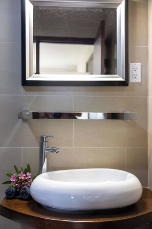 A bathroom with a white sink, a mirror, and a towel rack.