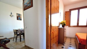 A room with a bed, a wooden door, a table with chairs, and a window. - Teoma Holiday Home With Climate and Parking for 5 Guests (Melendugno)