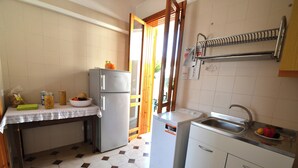 A compact kitchen with a refrigerator, sink, and a small countertop. - Teoma Holiday Home With Climate and Parking for 5 Guests (Melendugno)