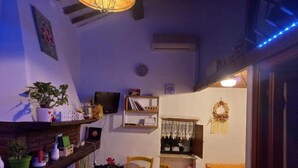 Ein gemütlicher Essbereich mit Tisch, Stühlen und Regalen mit verschiedenen Gegenständen.