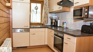 A compact kitchen with a dishwasher, oven, microwave, and a coffee maker. - House 47 the House to Stay for Holidays (Oberharz am Brocken)