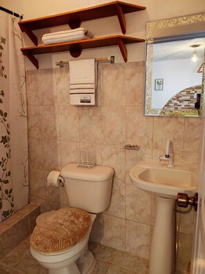 A bathroom with a toilet, sink, and a mirror with a decorative frame. - Bay View Apt Quiet Area Weekly - Monthly Discount (Samaná)