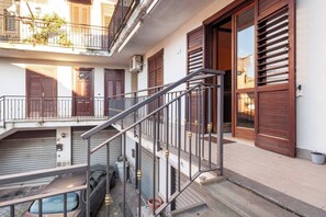 Un immeuble à plusieurs étages, doté d’un escalier, de balcons et de grandes portes en bois.