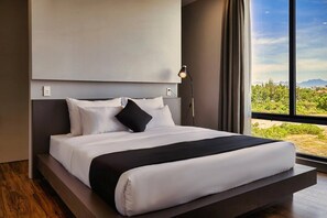 Quarto moderno com uma cama grande, vista para o verde lá fora e design minimalista.