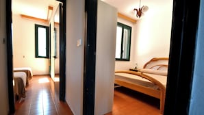 Ein Zimmer mit einem Bett, einem Nachttisch und einem Fenster.