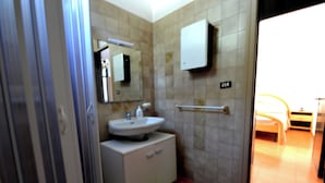 Ein Badezimmer mit Waschbecken, Spiegel, Schrank und Handtuchhalter.