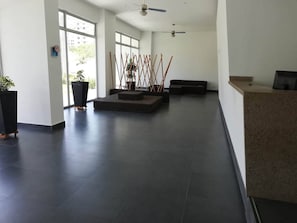 A spacious lobby with a reception desk, seating area, and large windows allowing natural light. - Aparta-suit Exclusive Rodadero (Santa Marta)