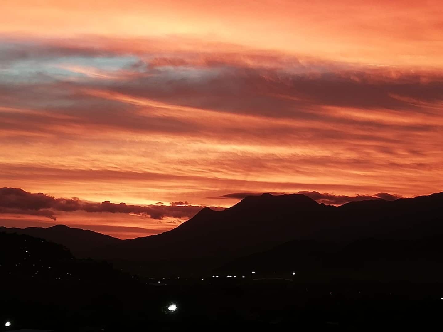 La silhouette d’une chaîne de montagnes se détache sur le ciel au coucher du soleil.