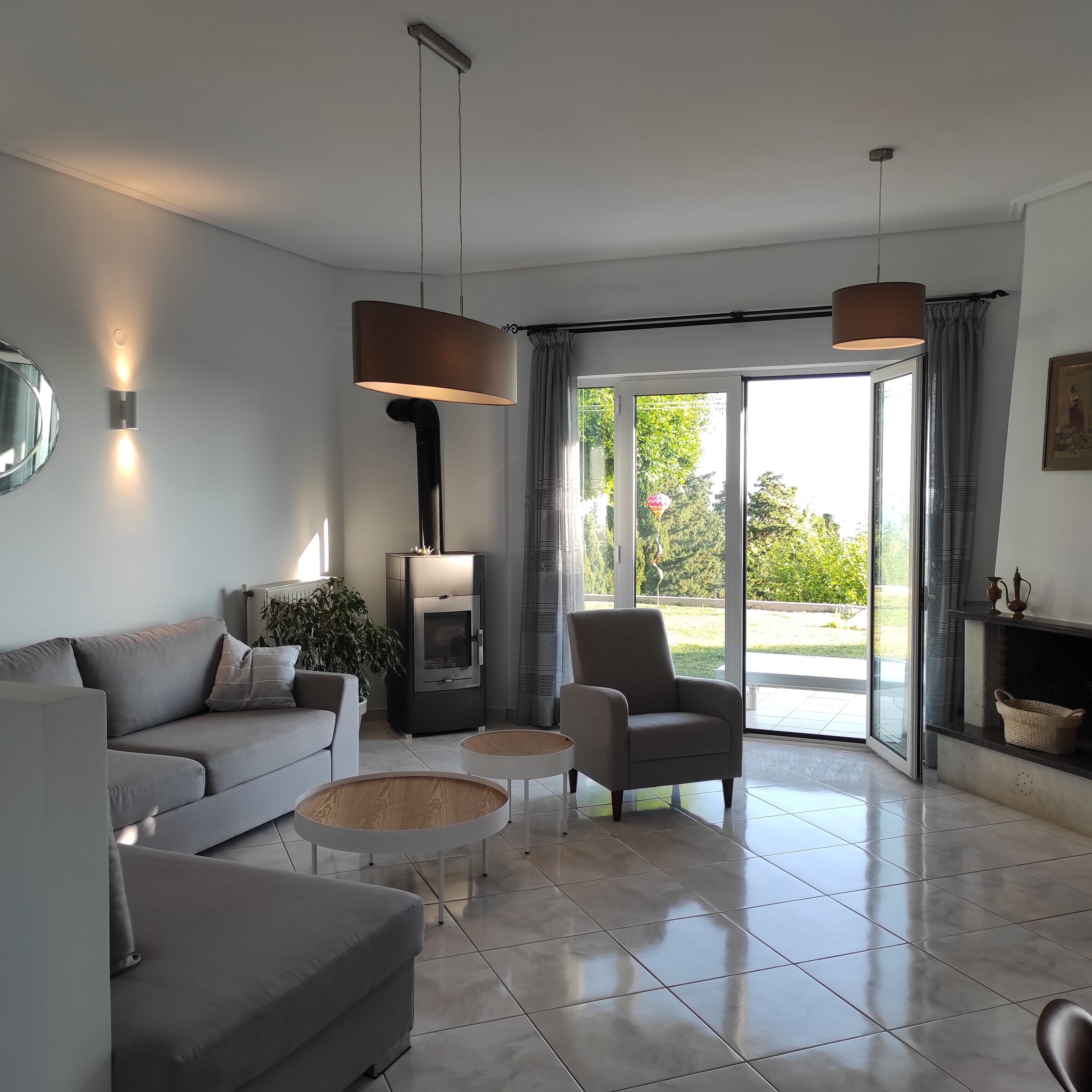 Un salon moderne avec un canapé, un fauteuil, une table basse et une cheminée.