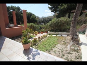 Enjoy a serene outdoor space surrounded by lush plants and a small lawn area.