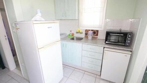 A compact kitchen with a white refrigerator, a microwave, and a sink. - Room-pelagos Studios by Frangki (Aegina)