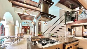 A spacious kitchen with a gas stove, modern appliances, and a view of the dining area. - 8aps-4 Luxury House in the Historic Center With Pool Air Conditioning and Wifi (Cartagena)