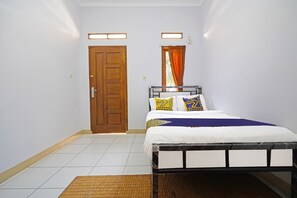 Une chambre à coucher avec un lit, une porte en bois et une fenêtre avec des rideaux.