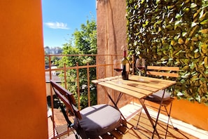 A balcony with a table, chairs, a wine bottle, and glasses. - Spacious Apartment In Heart Of Zagreb (Zagreb)