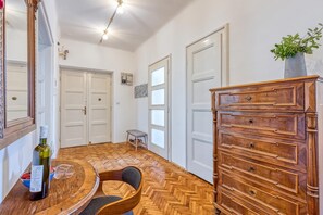A room with a wooden herringbone floor, a wooden dresser, and a mirror with a decorative frame. - Spacious Apartment In Heart Of Zagreb (Zagreb)