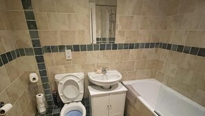 A bathroom with a toilet, sink, and bathtub. - Lovely 1-bed Apartment in Town Centre Colchester (Colchester)