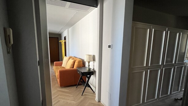 A hallway leading to a living area with a sofa, a lamp, and a wardrobe. - Loft33 (Barletta)