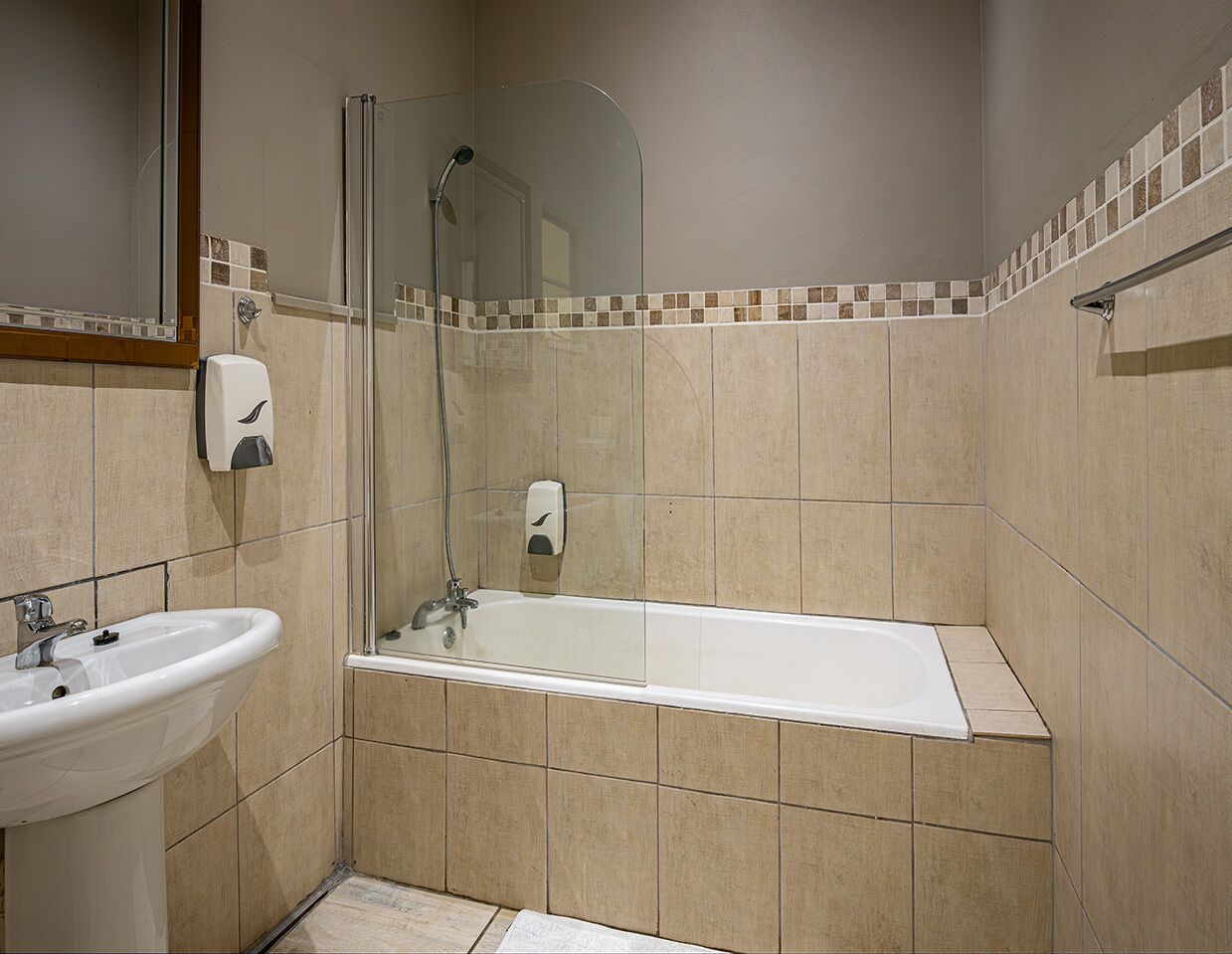 Un baño con bañera, lavamanos y ducha.