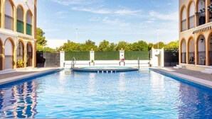 A rectangular swimming pool with a clear blue water surface, surrounded by a white pool deck.
