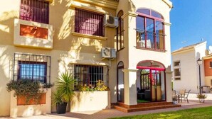 A two-story building with large windows and a covered entrance. - Lovely Groundfloor with swimming pool (Torrevieja)