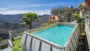 A pool with a clear view of the surrounding landscape, including mountains and a red-roofed building. - Vacation home Kenzo by Interhome (Bagni di Lucca)